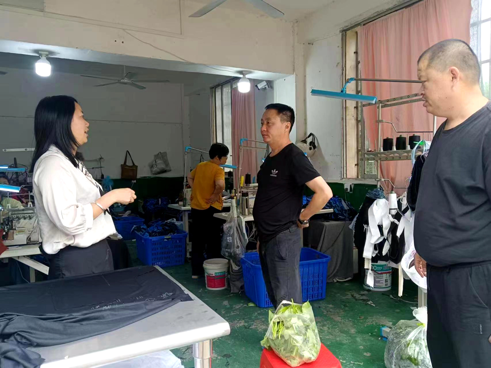 王红（左一）在顺江社区服装加工厂摸排用工需求