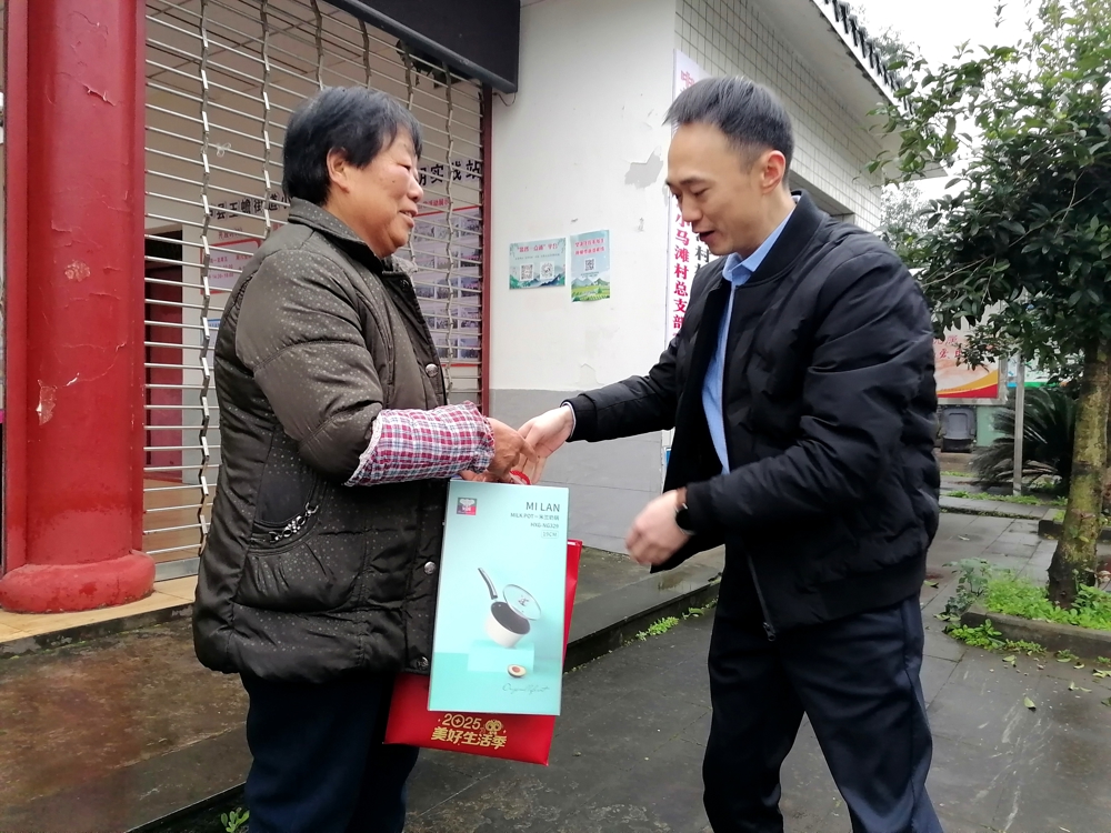 邮储银行泸县支行行长陈强在泸县玉蟾街道小马滩村为农民工留守家人代表送上暖心慰问物品